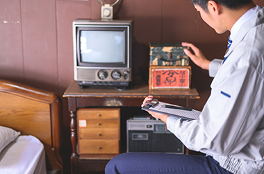 部屋の物をチェックする男性